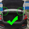 Rear view of a black car trunk with green circles highlighting the lift mechanism.
