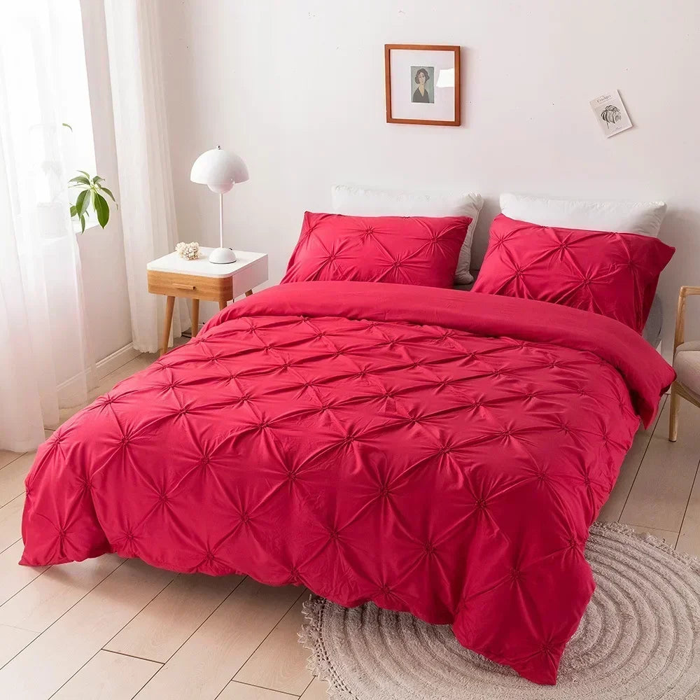 A vibrant red 3D pinch pleated duvet cover set displayed on a bed in a bright room.