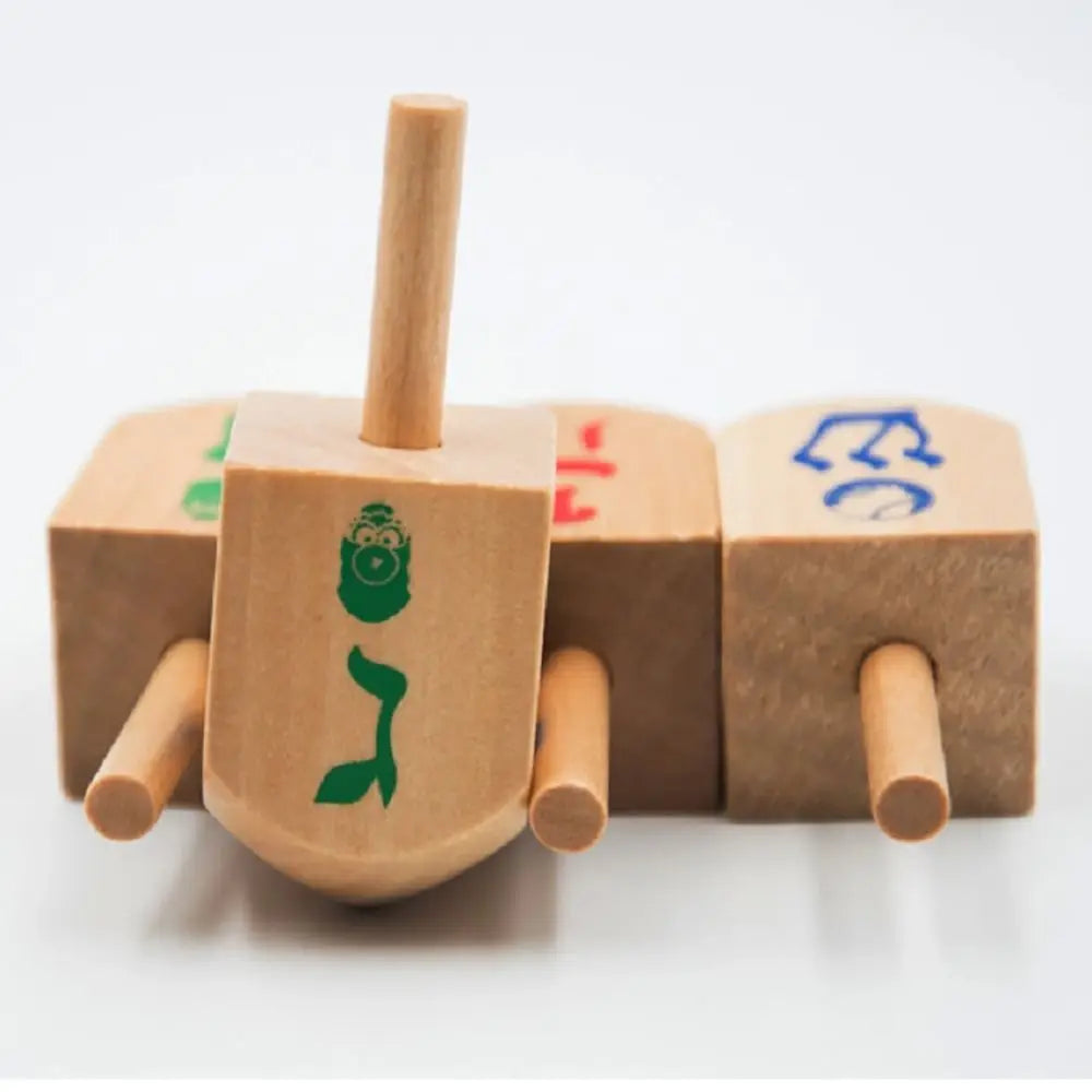 A set of wooden spinning tops used for Hanukkah and kids' play, featuring various designs.