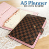 A pink A5 planner with a brown checkered binder cover and a white page inside.