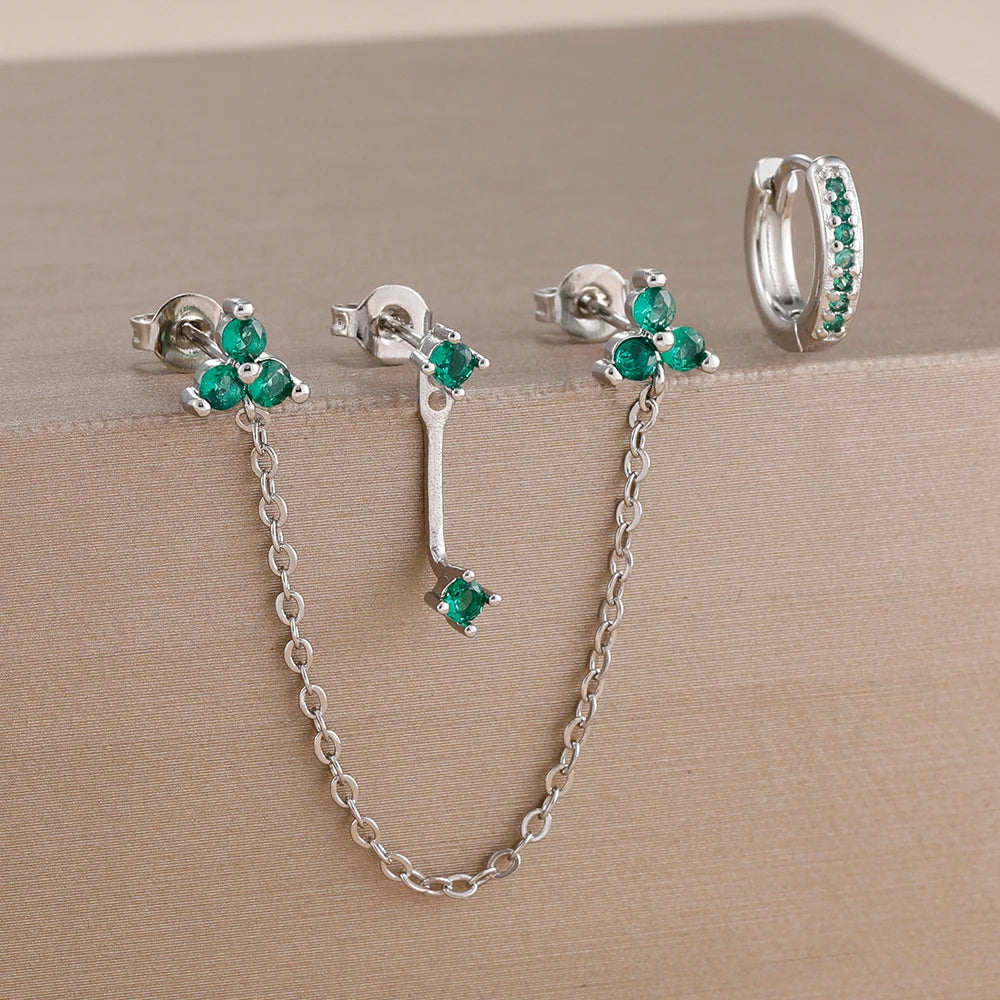 Boucles d'oreilles en chaîne doubles trous argentées avec des pierres de zircon vertes.