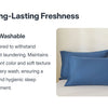 A set of solid blue pillow covers displayed on a bed, emphasizing long-lasting freshness and washability.