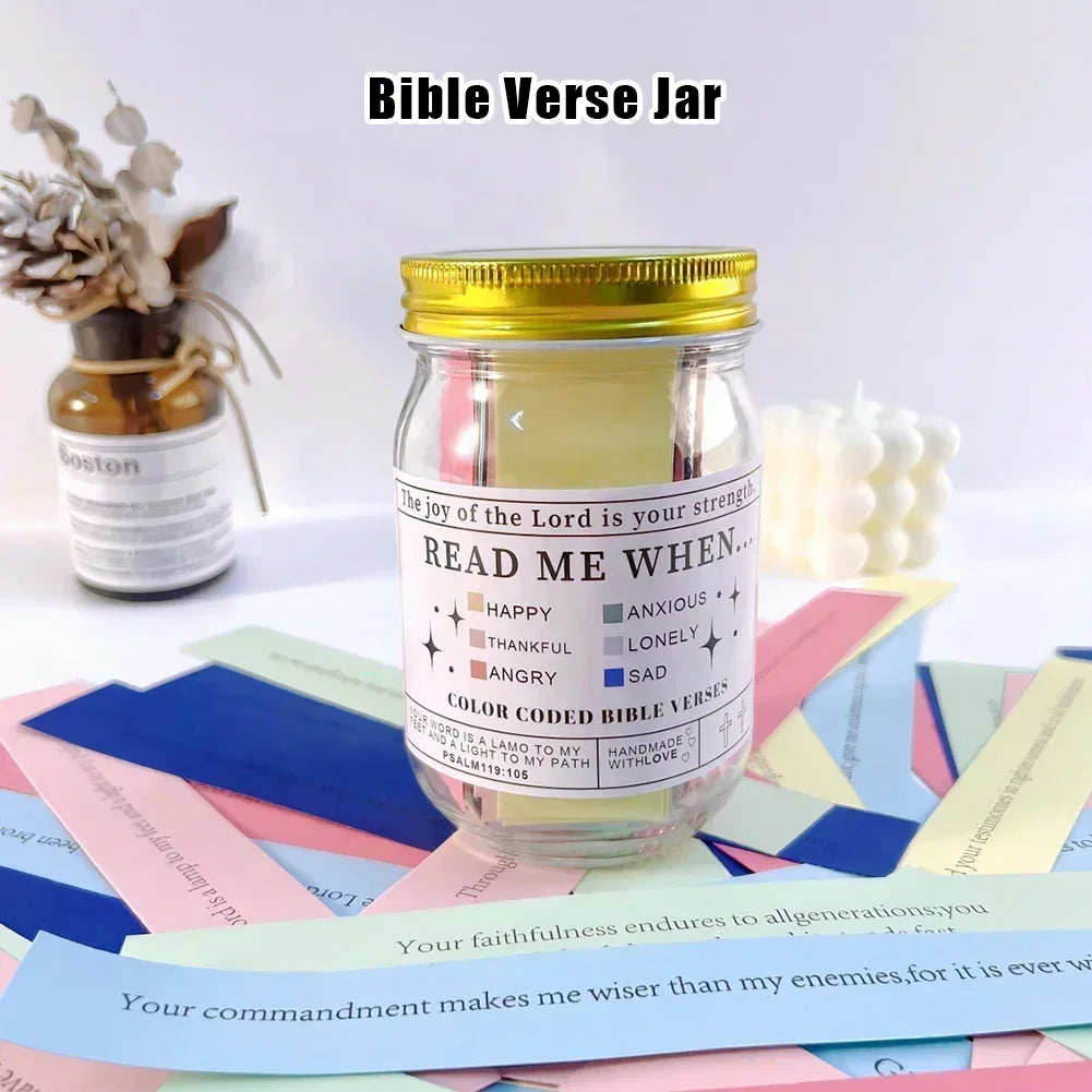 Un bocal en verre rempli de versets bibliques colorés sur une surface avec du papier rose et bleu.