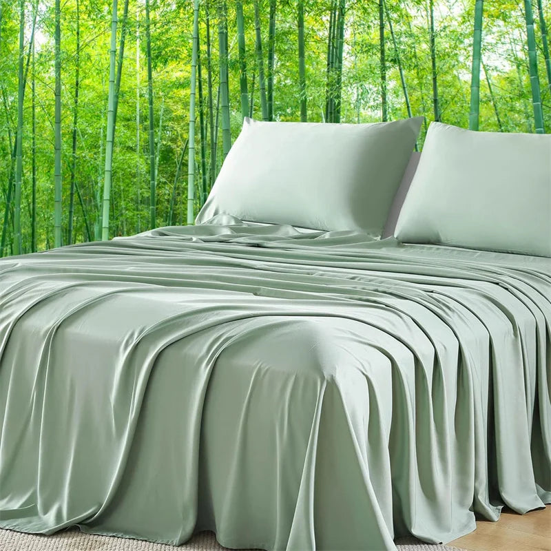 Luxuriöses Bambus-Bettlaken-Set in Salbeigrün, drapiert über ein Bett mit Hintergrund aus dichtem grünen Bambuswald.