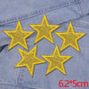 Set of five gold glitter star iron-on embroidered patches on a denim fabric.
