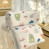 A rolled white comforter with a panda print featuring various cute animal faces and shapes, displayed near a window.