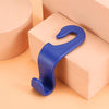 A pair of blue universal car seat headrest hooks resting on a light peach-colored box.