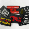 A collection of black embroidered iron-on patches with humorous text like BAD DECISIONS MAKE STORIES and I PULL OUT