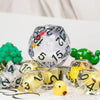 A collection of clear resin dice and a yellow animal figurine are displayed on a white surface.