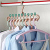 A wooden hanger organizer with nine numbered hooks and a pink plastic hanger rack displaying light blue shirts.