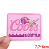 Pink embroidered patch with the word Cools and Cattle in pink and gold thread