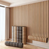 Vertical wood grain peel-and-stick wall tiles installed on a light-colored wall with vertical slats and a wooden floor.