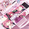 A pink anime character illustration on a mouse pad featuring a girl with pink hair and a white shirt.