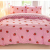 Pink strawberry print duvet cover set with matching pillowcases displayed on a bed.