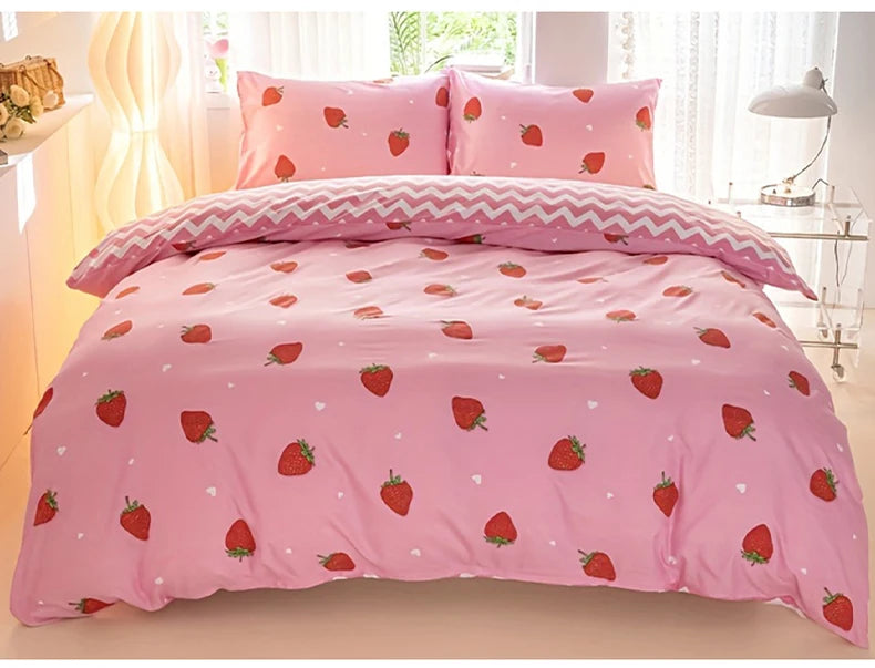 Pink strawberry print duvet cover set with matching pillowcases displayed on a bed.