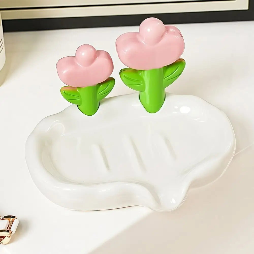 A pink tulip drainage soap dish with green stems and a white non-slip tray.