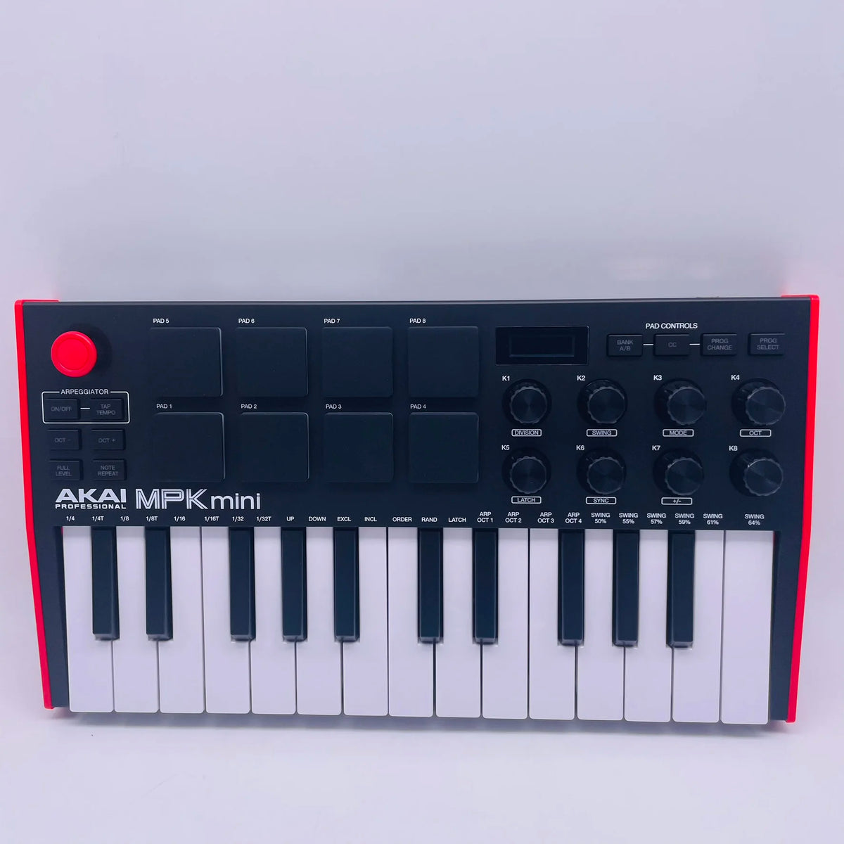 A black AKAI MPK Mini professional MIDI keyboard controller with 25 keys, drum pads, and knobs.