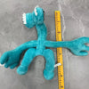 A teal plush toy of an Opila bird from Garten of BanBan is displayed next to a yellow ruler.
