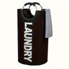 A dark brown foldable laundry basket with padded handles and a gray towel hanging over the side.