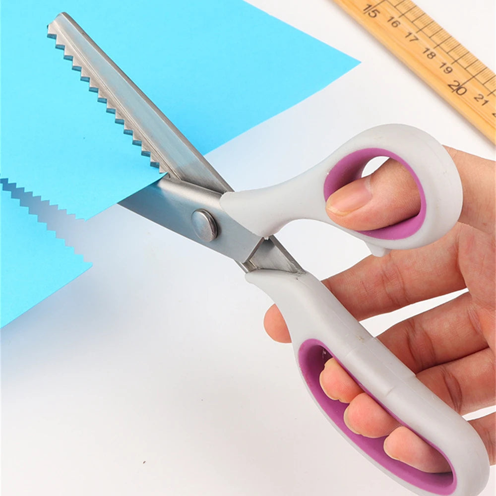 A hand holds a pair of professional pinking shears with stainless steel blades cutting blue paper.