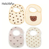 Two light beige baby cotton gauze bibs with cute bear and rainbow patterns