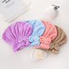 A collection of purple, blue, and pink microfiber hair drying towels with bow-knot head wraps displayed on a white surface.