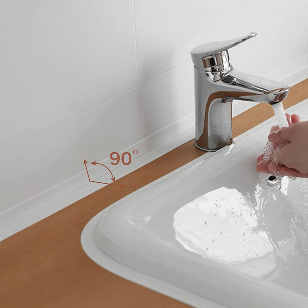 Nahaufnahme eines modernen Küchenhahns, der Wasser mit einem 90-Grad-Sprühwinkel in eine weiße Spüle gießt.