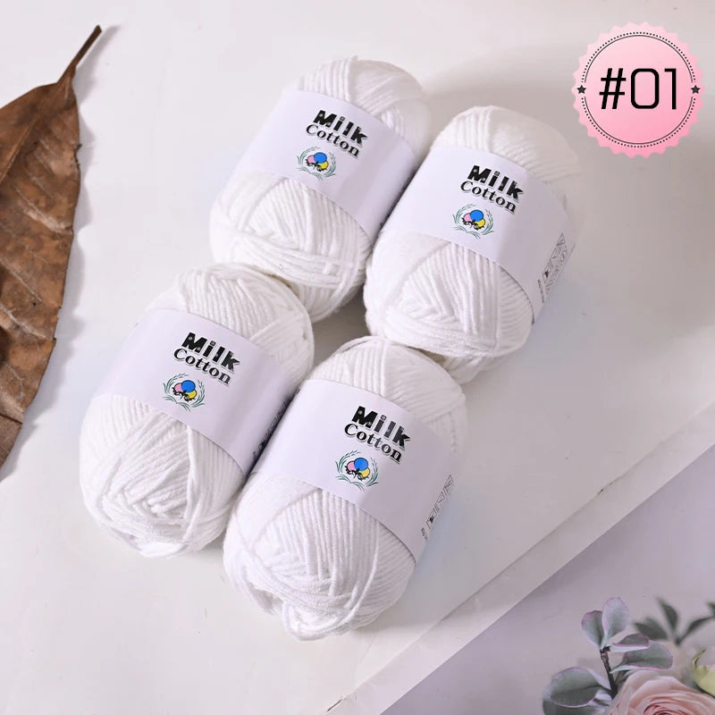 A pile of white Milk Cotton yarn balls labeled #01 for knitting and crochet projects.