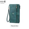 A teal leather bifold wallet with a zip-around closure and wristlet strap in peacock blue.