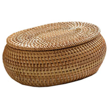 Handwoven rattan storage basket with a lid, made of natural tan fibers.