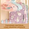 A set of pink and blue thickened material load-bearing baby clothes hangers displayed on a wooden rack.