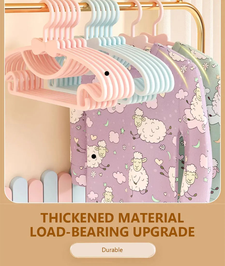 A set of pink and blue thickened material load-bearing baby clothes hangers displayed on a wooden rack.