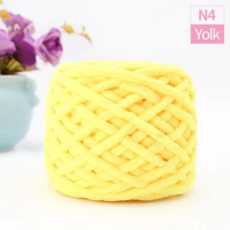 A ball of bright yellow chunky chenille yarn used for knitting and crochet projects.