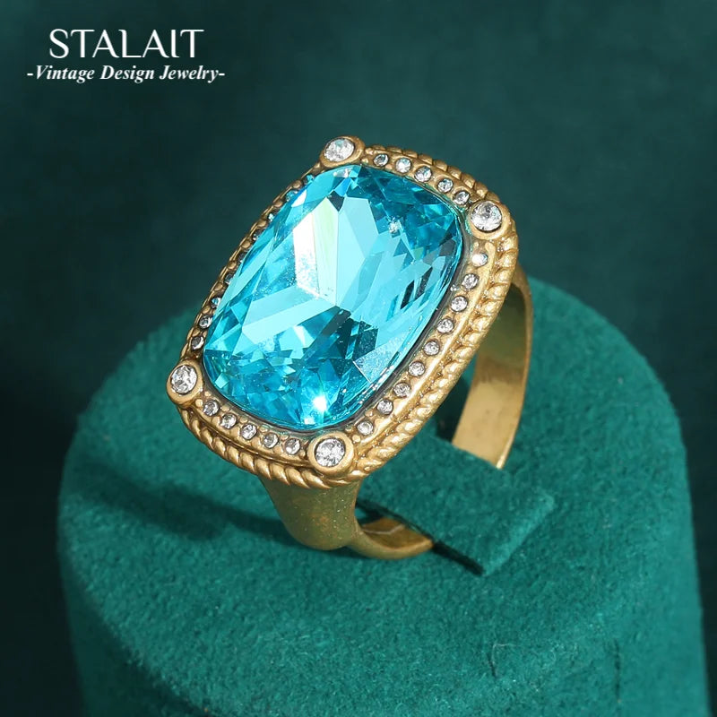 A vintage sea blue crystal cocktail ring featuring a large, brilliant blue gemstone set in gold-toned metal.