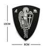 A black shield patch featuring a silver archangel St. Michael design with the letters AM.