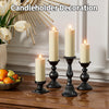 A set of pillar candles in a decorative candelholder arrangement on a wooden table.