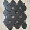 A pattern of dark gray hexagonal mosaic tiles installed on a light beige wall surface.