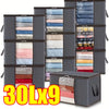 Nine dark gray storage bags with transparent windows filled with folded textiles like quilts and blankets