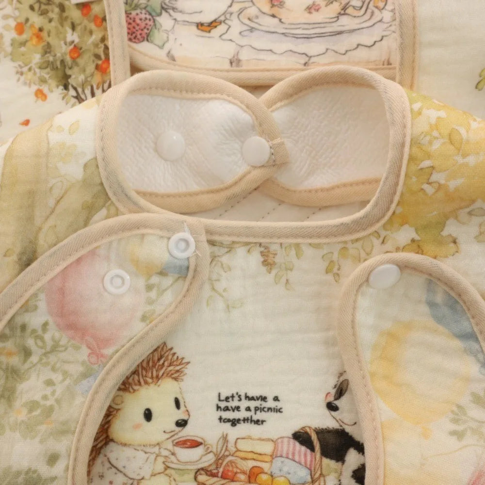 A light beige soft cotton waterproof baby bib with an adjustable neck and floral pattern.