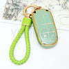 A lime green TPU car key fob cover attached to a braided cord, resting on a white surface.