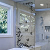 A glass shower enclosure featuring black flower and butterfly decorative vinyl stickers on the door panel.