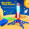 A colorful flash rocket toy with a glowing tip and blue launcher is shown against a starry background.
