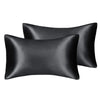 A set of two black silky satin pillowcases for hair and skin.