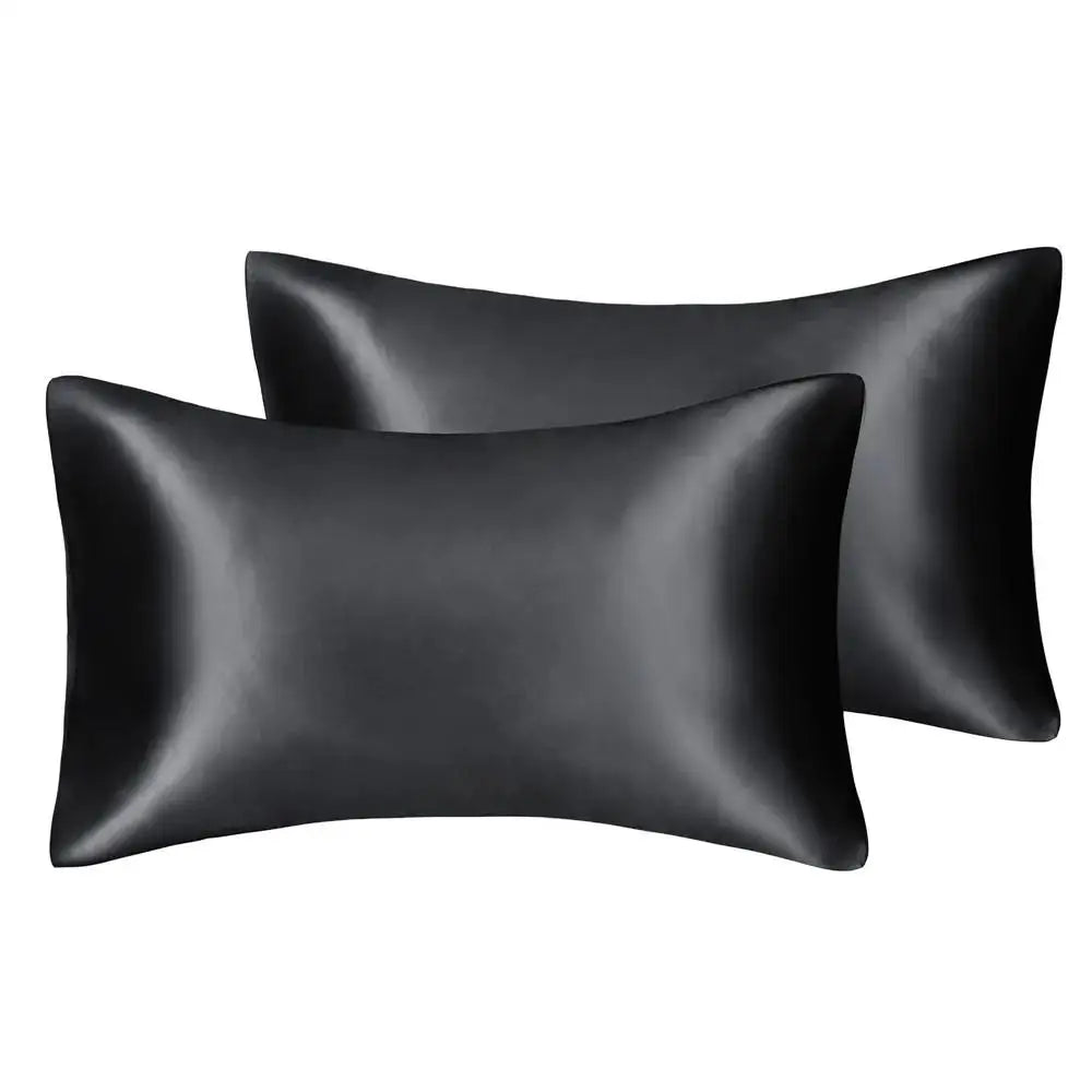 A set of two black silky satin pillowcases for hair and skin.
