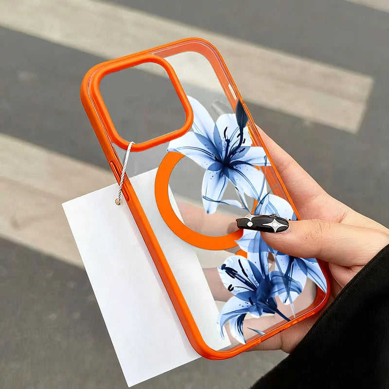 An orange magnetic phone case featuring a blue lily design is held in a hand against a white card.