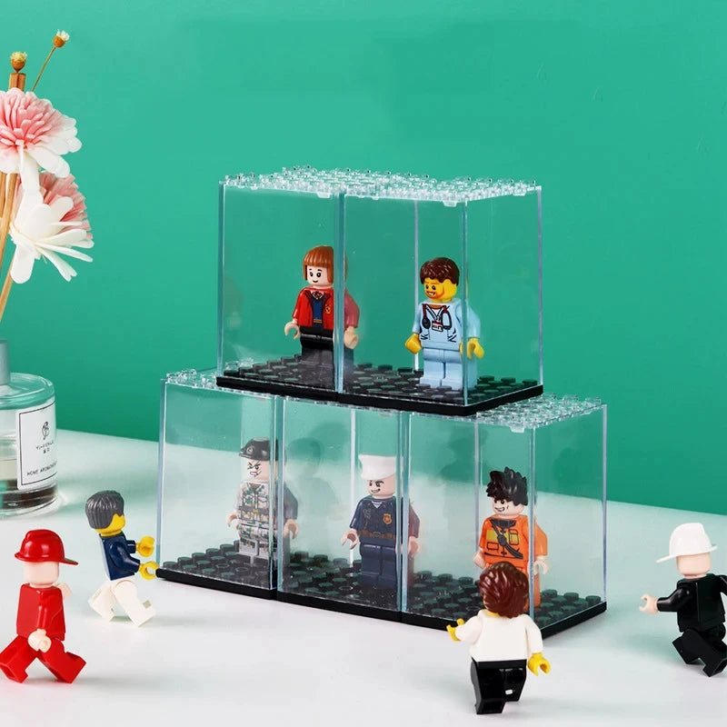 A clear acrylic display case holds various miniature figurines and collectibles on a black base.