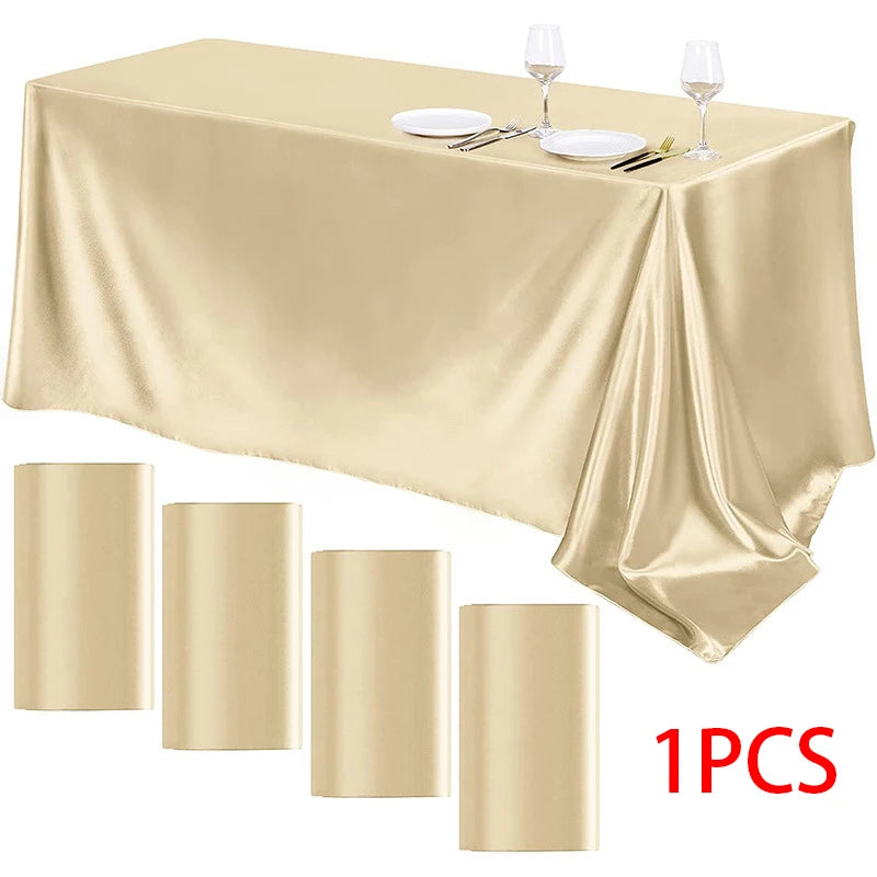 A luxurious satin gold tablecloth set with silverware and wine glasses displayed on a table.