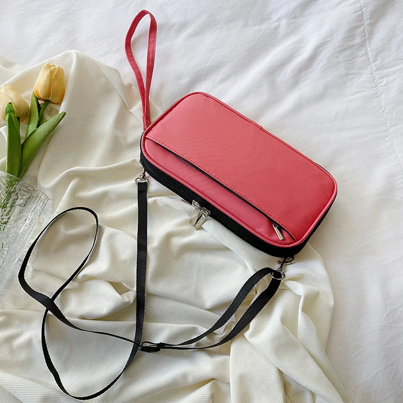 A pink waterproof family passport and document organizer wallet with a black strap lying on white fabric.