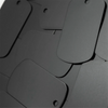 A close-up view of a stack of black aluminum stamping blanks for DIY engraving dog tags.
