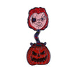 An enamel pin depicting Chucky the doll with red hair and a menacing expression.